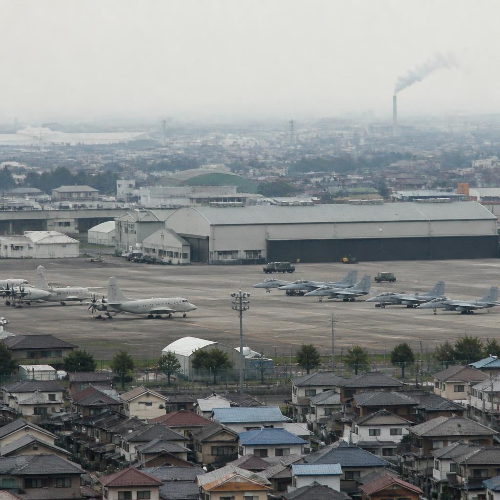 Industrial incinerator stack emitting smoke over a military housing area in Atsugi, Japan.